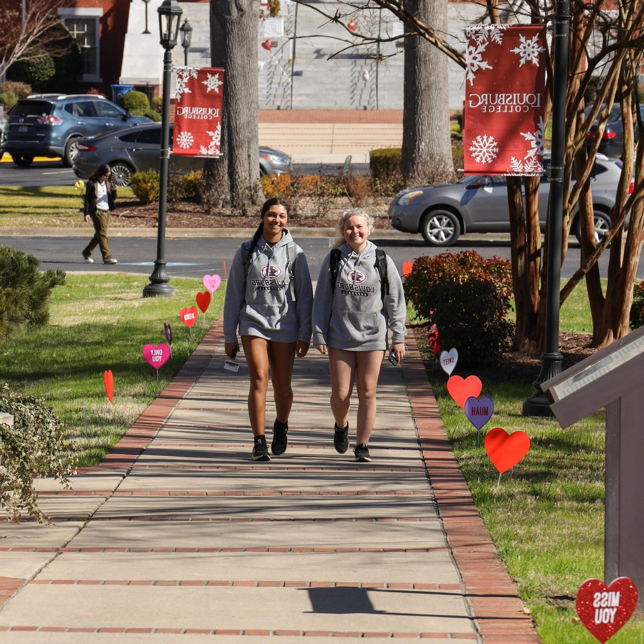 两个女学生走在校园里.